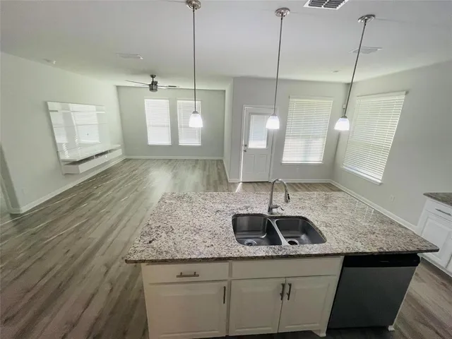 a kitchen with stainless steel appliances granite countertop a sink stove and wooden floor