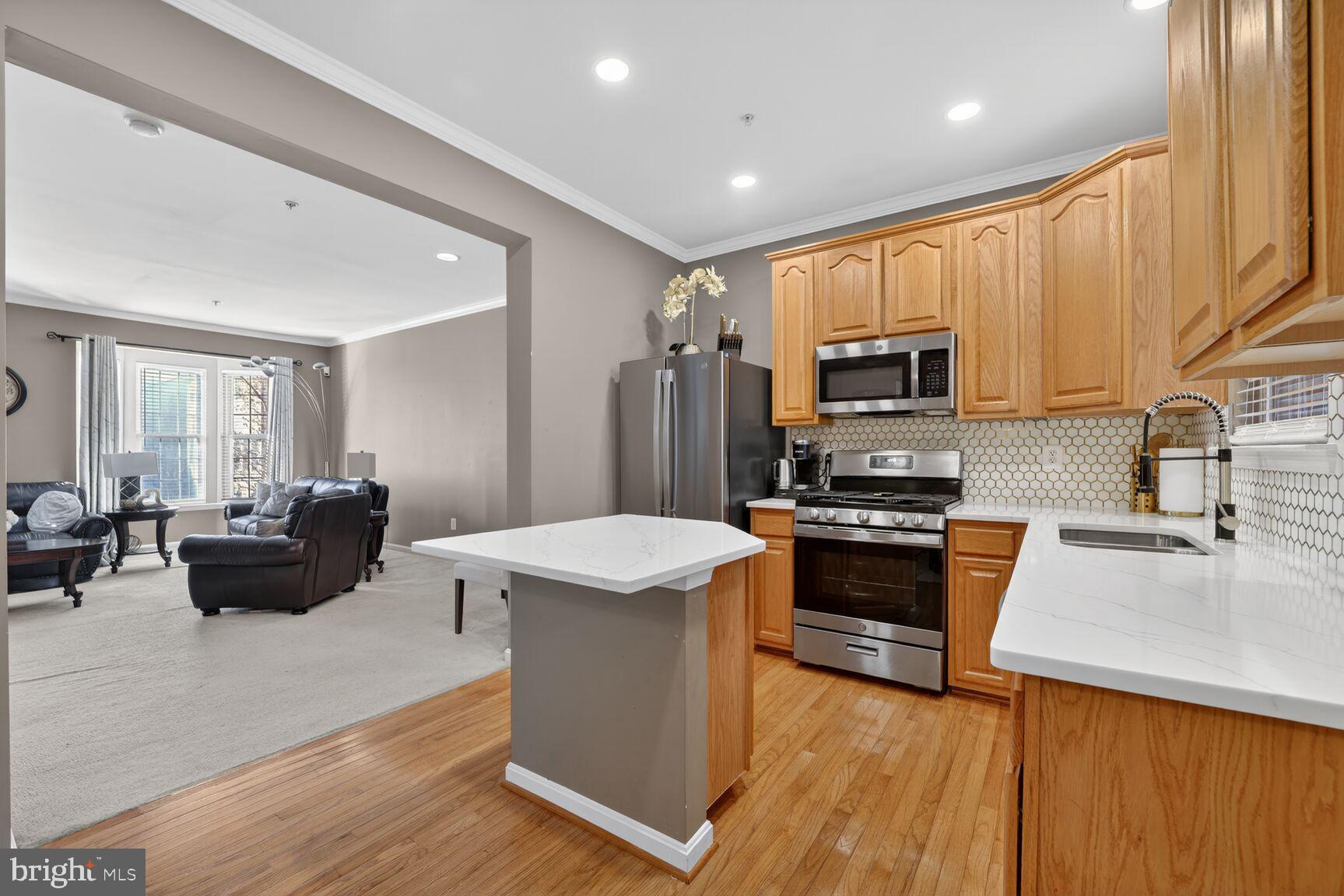 165 Tilden Way Edgewater, MD 21037 - Photo 7 of 22 a kitchen with stainless steel appliances a stove top oven a sink dishwasher a refrigerator and cabinets with wooden floor
