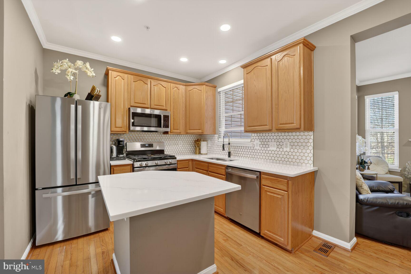 165 Tilden Way Edgewater, MD 21037 - Photo 8 of 22 a kitchen with a refrigerator a sink a stove a microwave and wooden cabinets