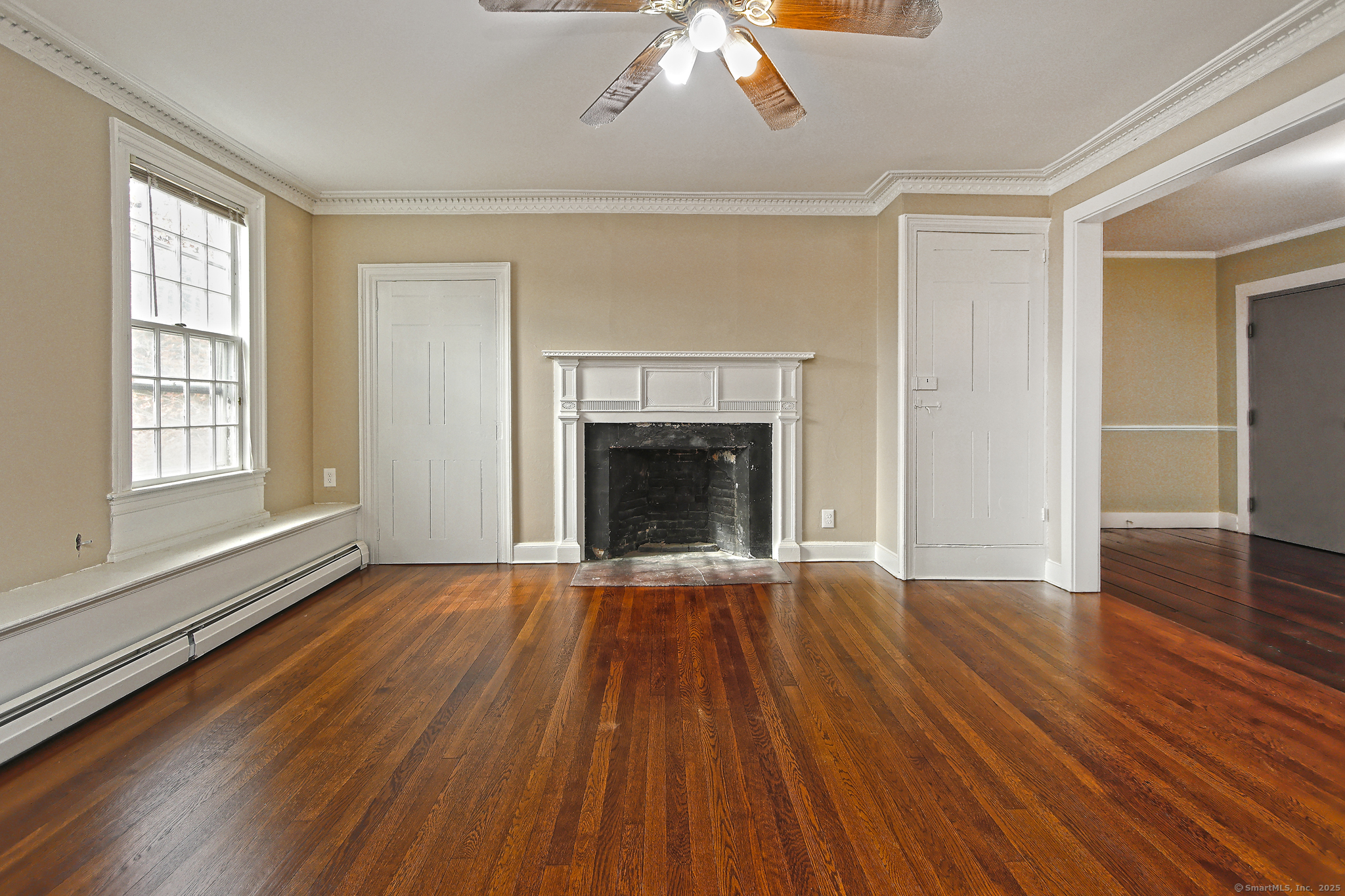 562 Amity Road, Unit D Bethany, CT 06524 - Photo 11 of 40 an empty room with wooden floor fireplace and windows