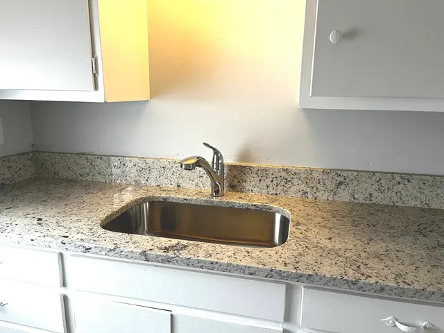 a kitchen with a refrigerator a stove top oven and cabinets