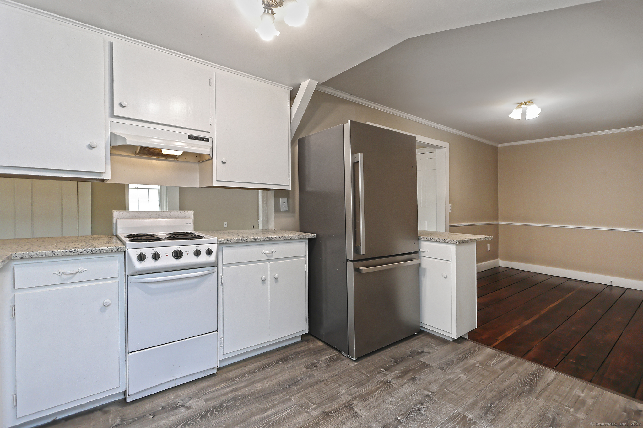 562 Amity Road, Unit D Bethany, CT 06524 - Photo 17 of 40 a kitchen with a refrigerator a stove top oven and cabinets