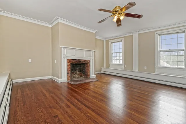 wooden floor fireplace and windows in an empty room