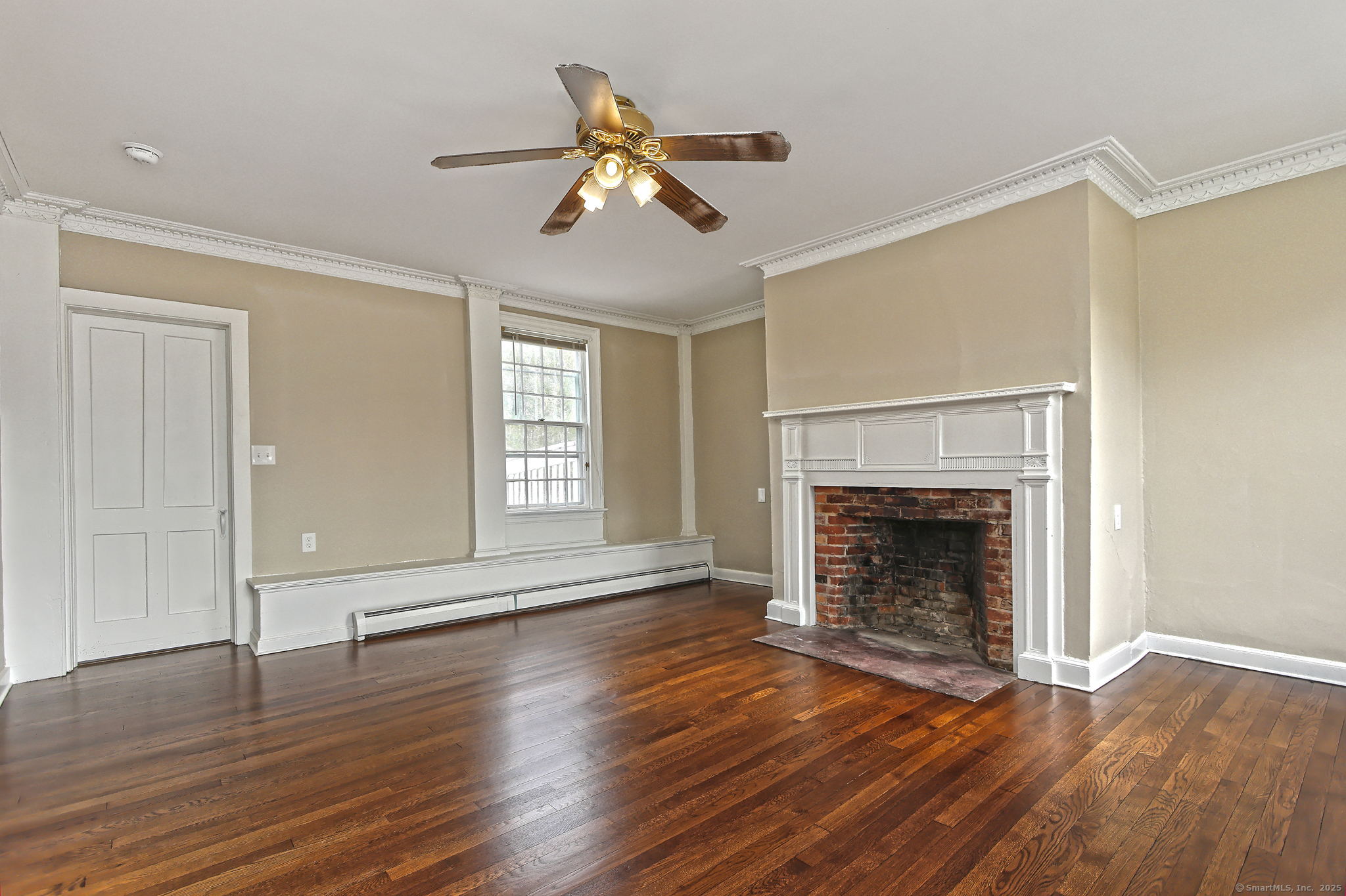 562 Amity Road, Unit D Bethany, CT 06524 - Photo 22 of 40 a view of an empty room with wooden floor fireplace and a window