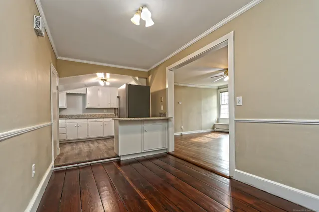 an empty room with wooden floor fireplace and windows