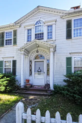 a front view of a house with a garden