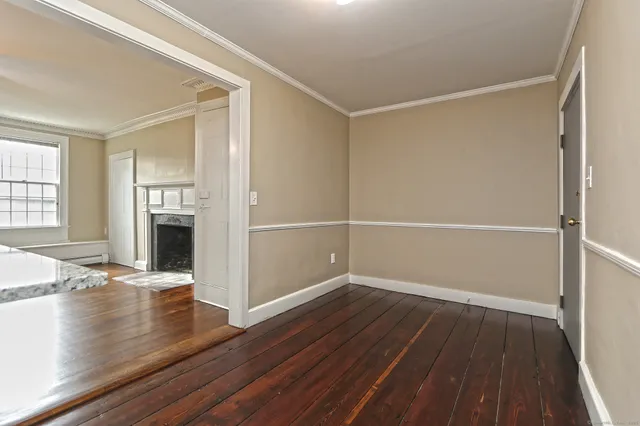 an empty room with wooden floor a fireplace and windows