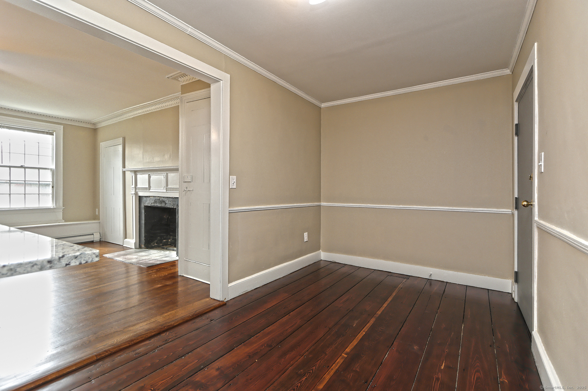 562 Amity Road, Unit D Bethany, CT 06524 - Photo 10 of 40 an empty room with wooden floor a fireplace and windows