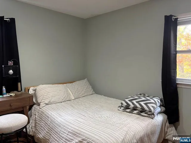 a bedroom with a bed and a flat tv screen on a dresser