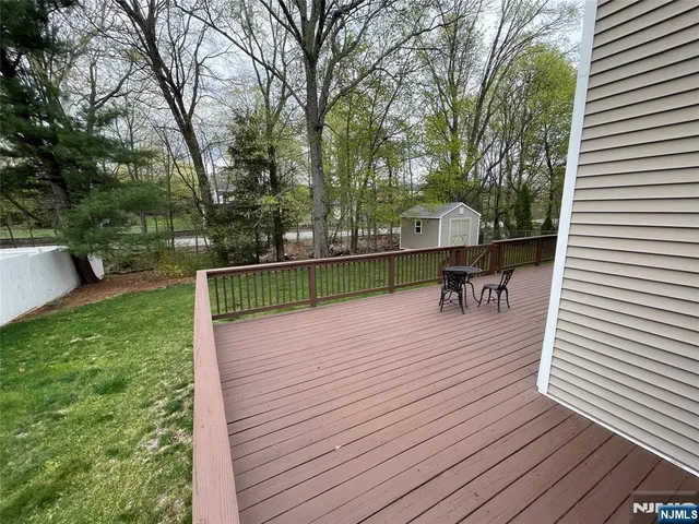 a view of a wooden deck with chairs and a yard