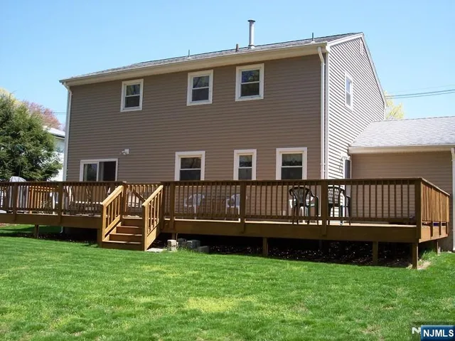 a view of a house with a backyard and deck