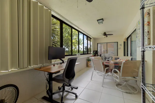 a view of a workspace with furniture and a window