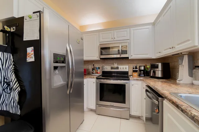 a kitchen with stainless steel appliances granite countertop a refrigerator stove and sink