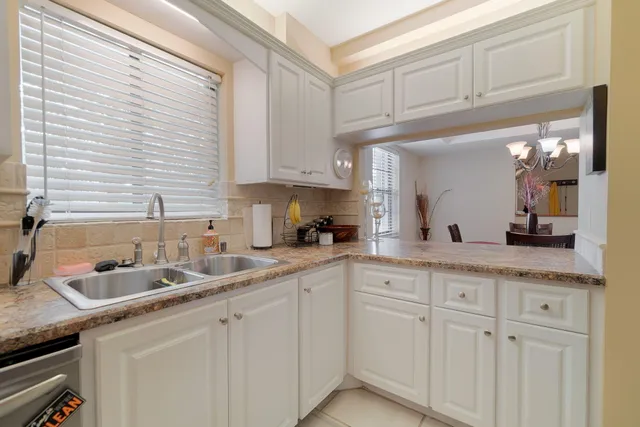 a kitchen with white cabinets and sink