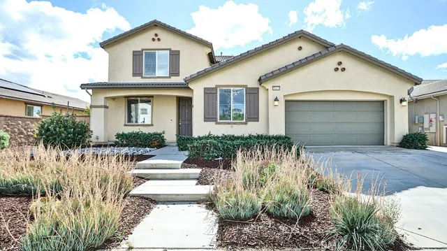 a front view of a house with a garden