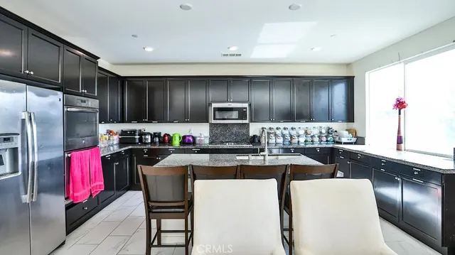 a kitchen with granite countertop stainless steel appliances and wooden cabinets