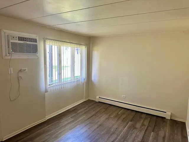 a view of a room with wooden floor and windows