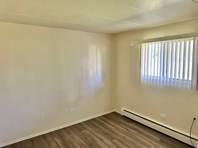 a view of a room with wooden floor and a window