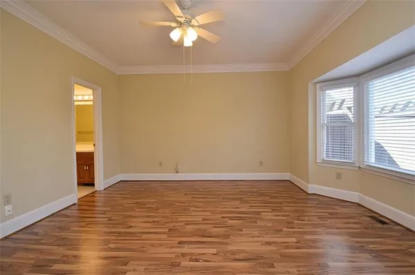 a view of an empty room with window and wooden floor