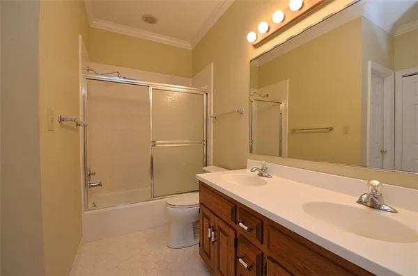 a bathroom with a double vanity sink toilet mirror and shower