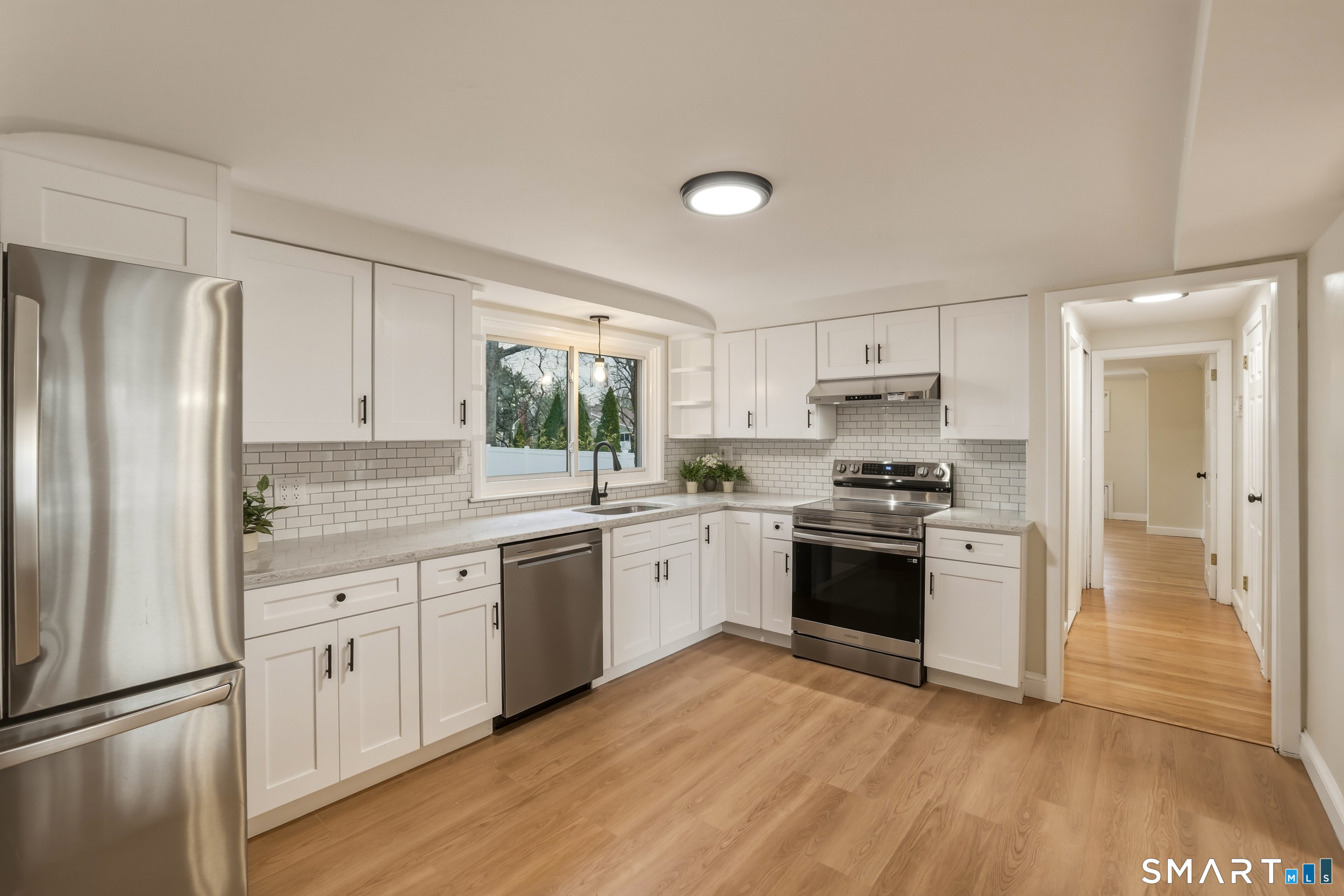 a kitchen with granite countertop a refrigerator stove top oven and sink