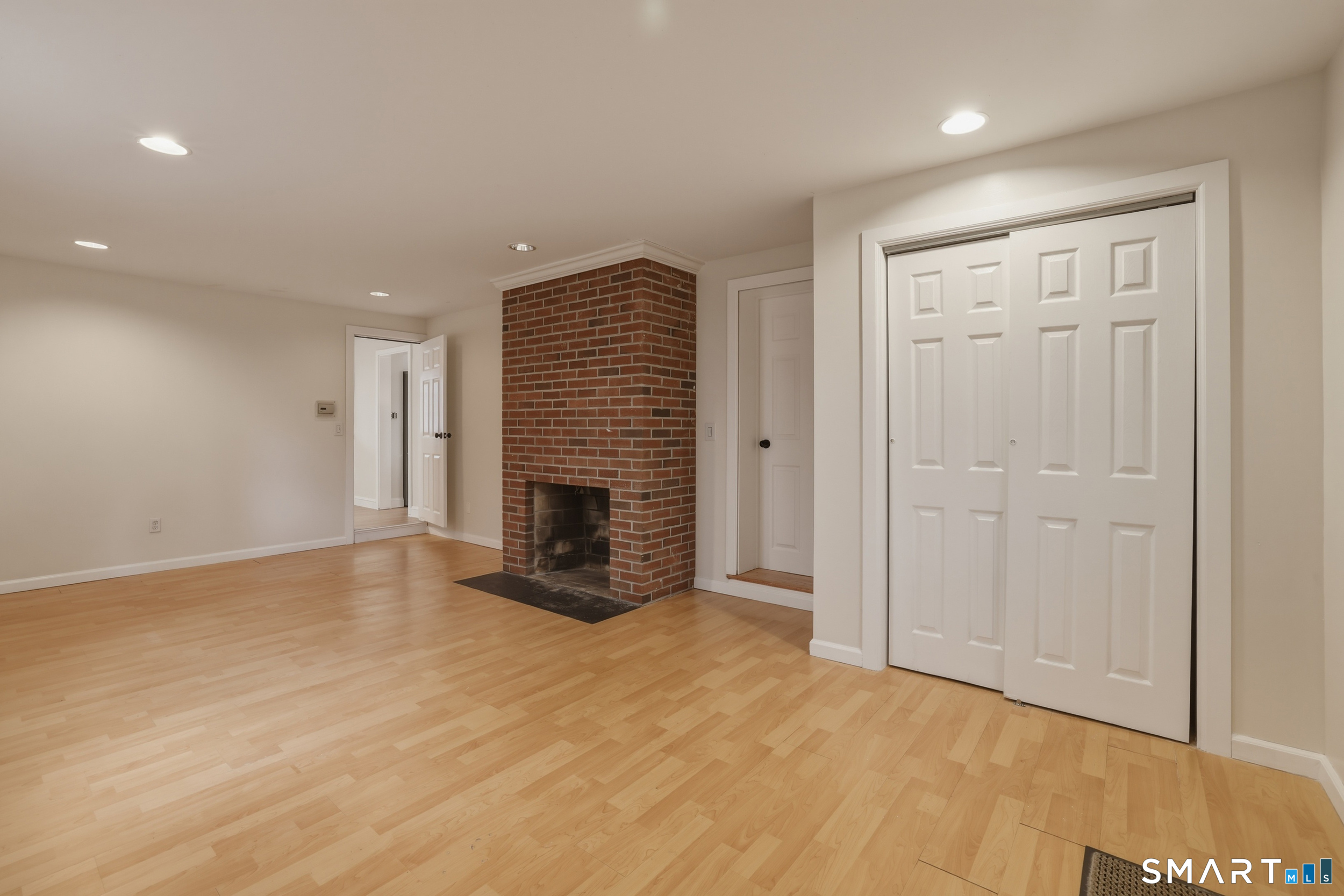 102 Lawler Road West Hartford, CT 06117 - Photo 17 of 42 an empty room with wooden floor and fireplace