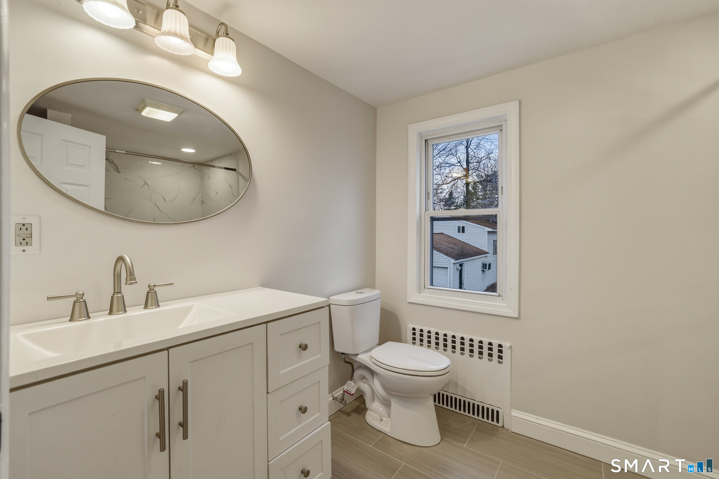 102 Lawler Road West Hartford, CT 06117 - Photo 26 of 42 a bathroom with a toilet a sink and mirror