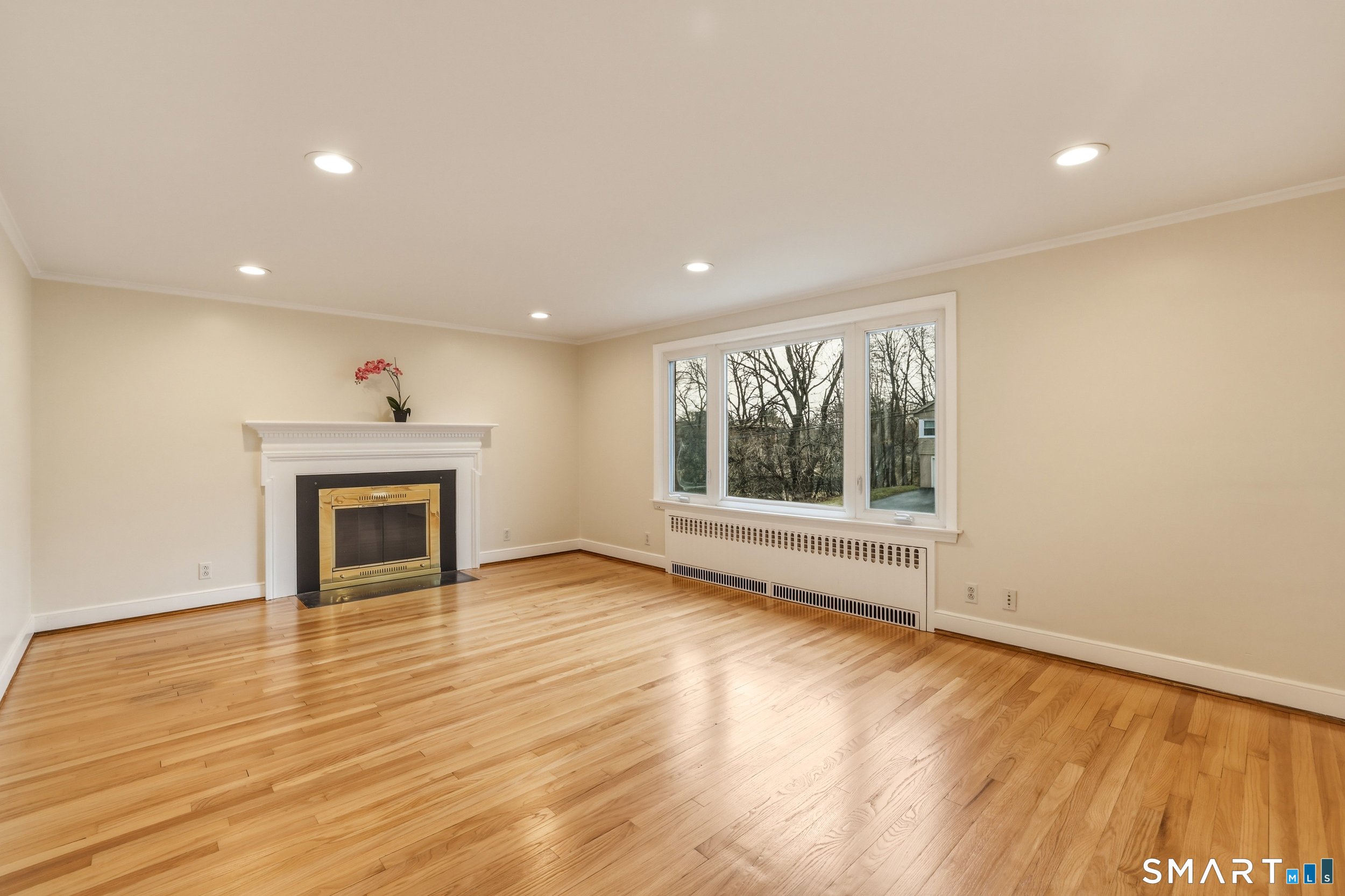 102 Lawler Road West Hartford, CT 06117 - Photo 6 of 42 a view of an empty room with wooden floor and a window