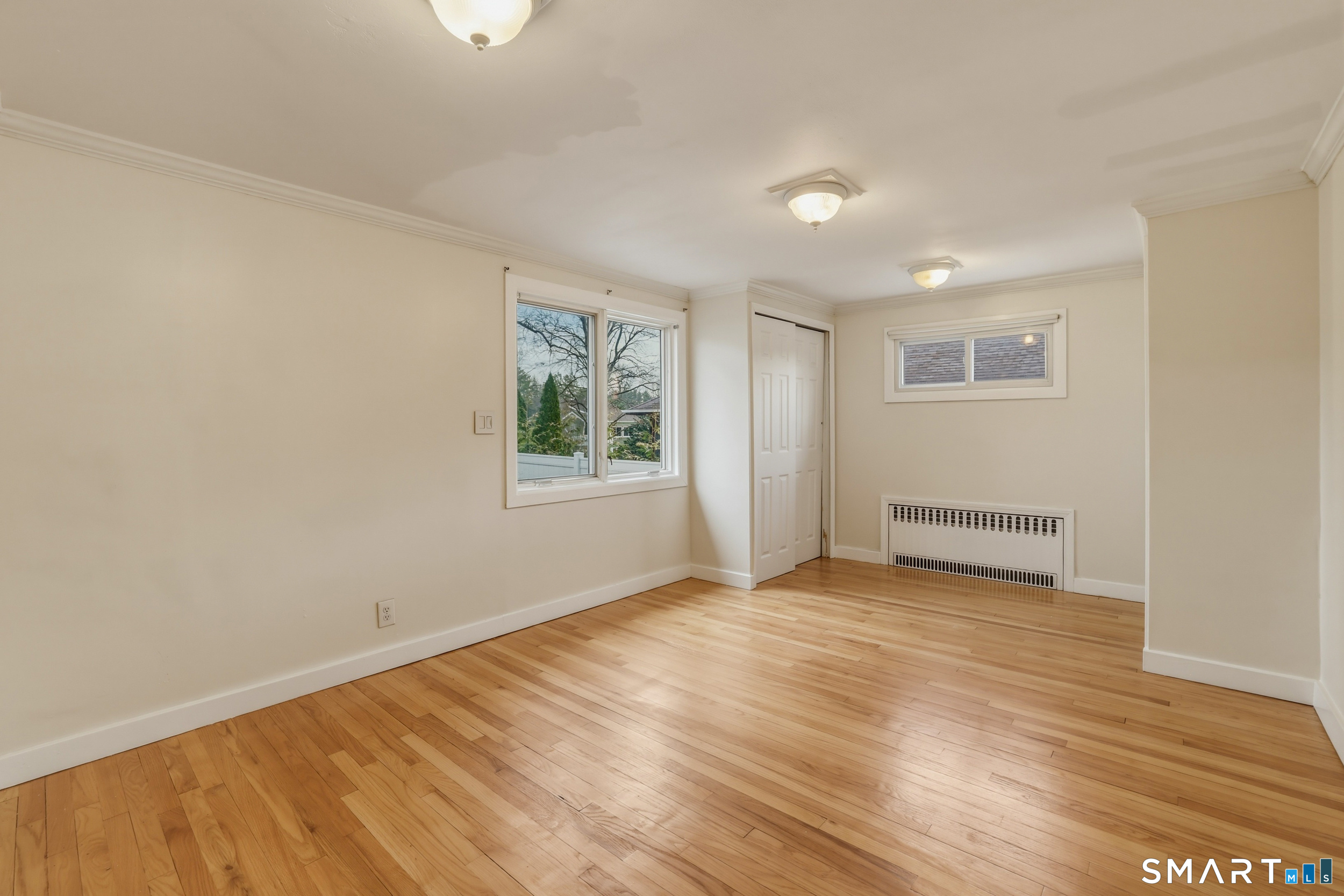 102 Lawler Road West Hartford, CT 06117 - Photo 9 of 42 an empty room with wooden floor and windows