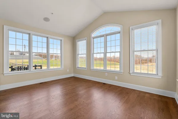 a view of a livingroom with a fireplace wooden floor and windows