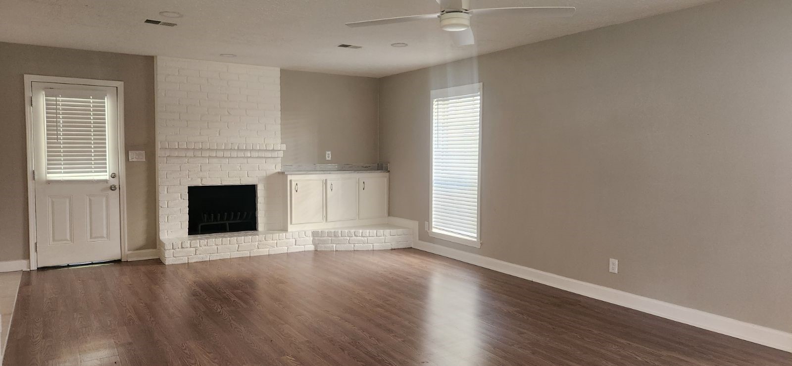 5006 Droddy Street Houston, TX 77091 - Photo 4 of 9 an empty room with wooden floor a fireplace and windows