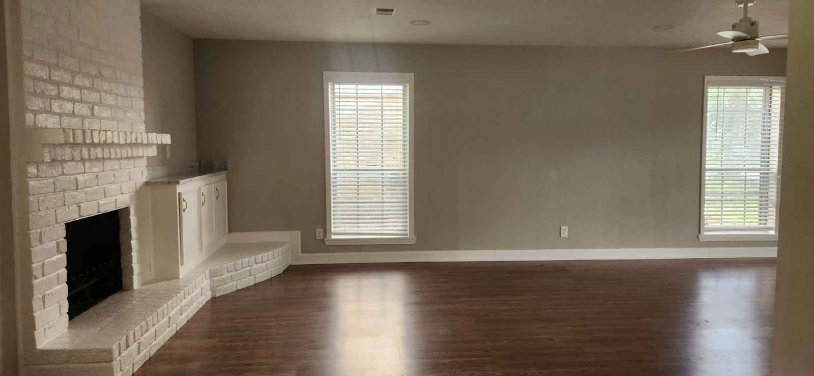 5006 Droddy Street Houston, TX 77091 - Photo 5 of 9 an empty room with wooden floor fireplace and windows