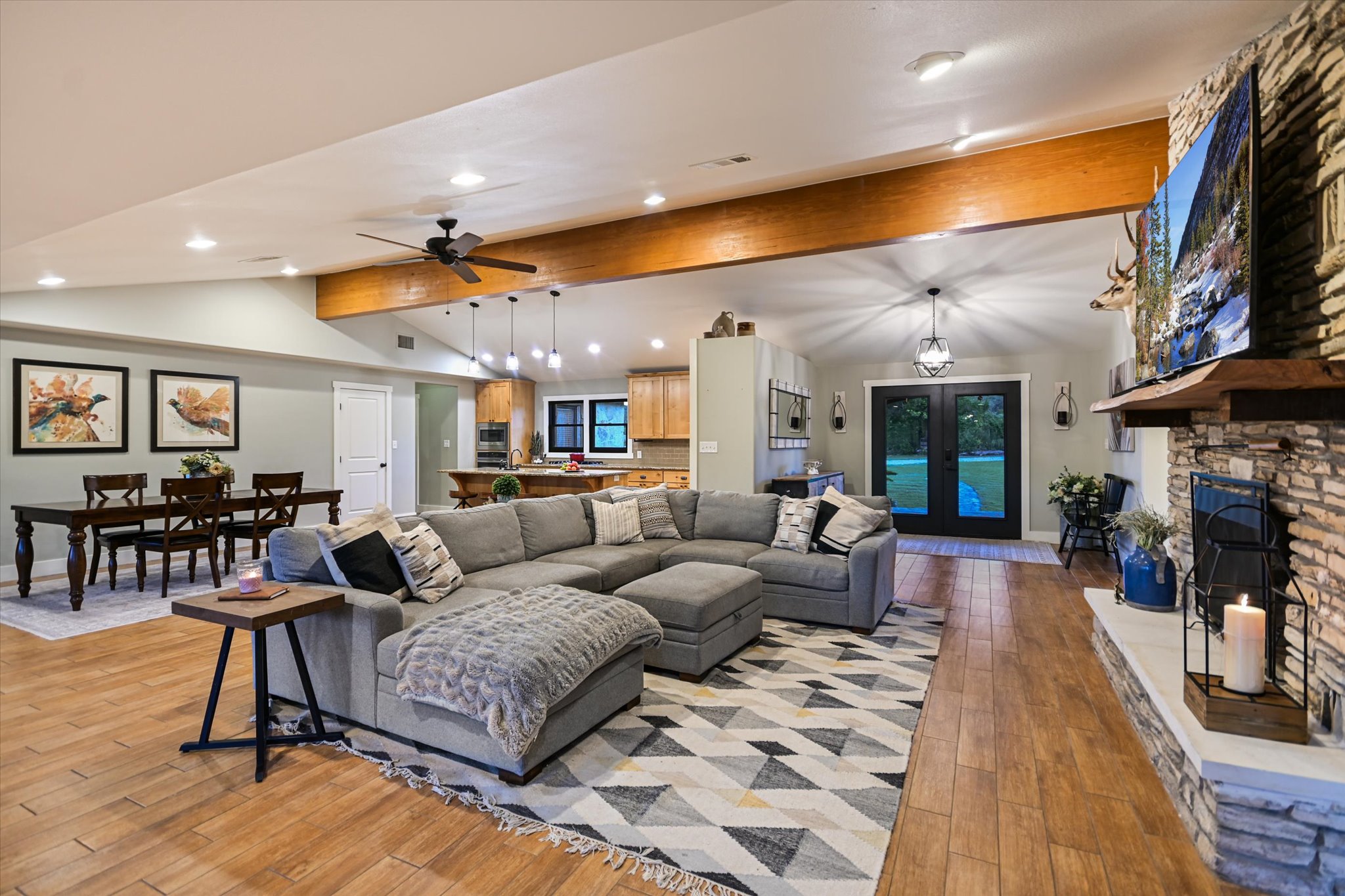 2411 Spoke Hollow Road Wimberley, TX 78676 - Photo 7 of 37 A spacious great room flows seamlessly with exposed beam accents, recessed lighting, and rich wood flooring.