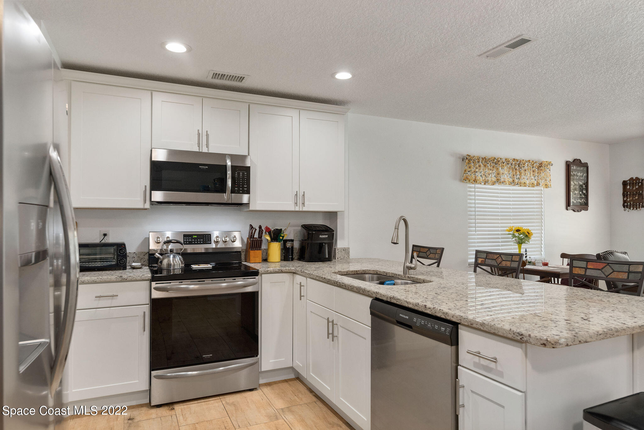 1821 Britt Road Cocoa, FL 32926 - Photo 19 of 63 a kitchen with sink a microwave a stove and cabinets