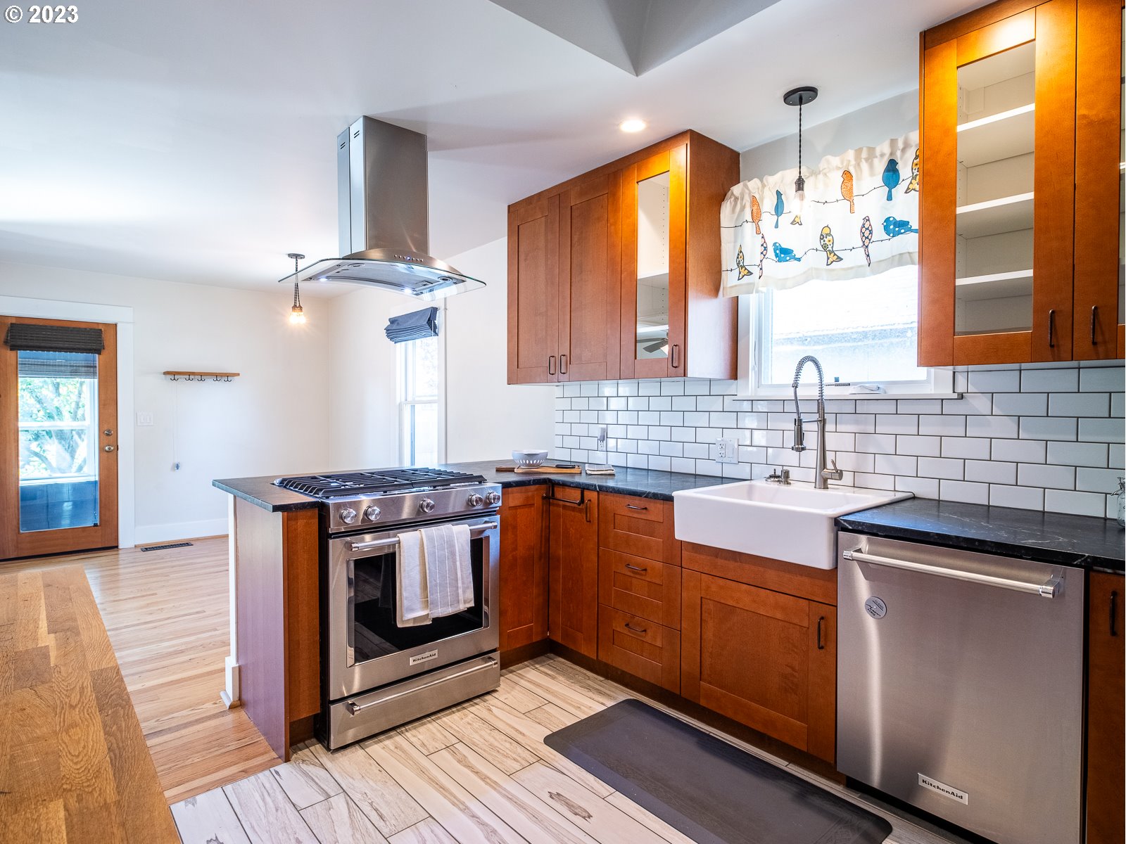 903 North Winchell Street Portland, OR 97217 - Photo 11 of 34 a kitchen with stainless steel appliances wooden cabinets and a stove top oven