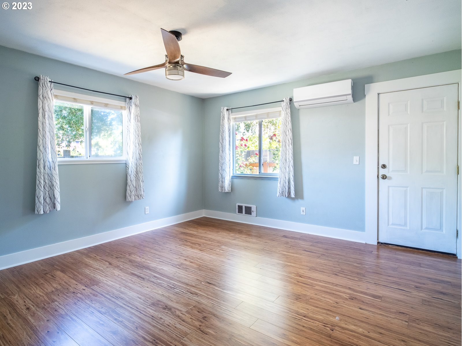 903 North Winchell Street Portland, OR 97217 - Photo 21 of 34 an empty room with wooden floor chandelier fan and windows