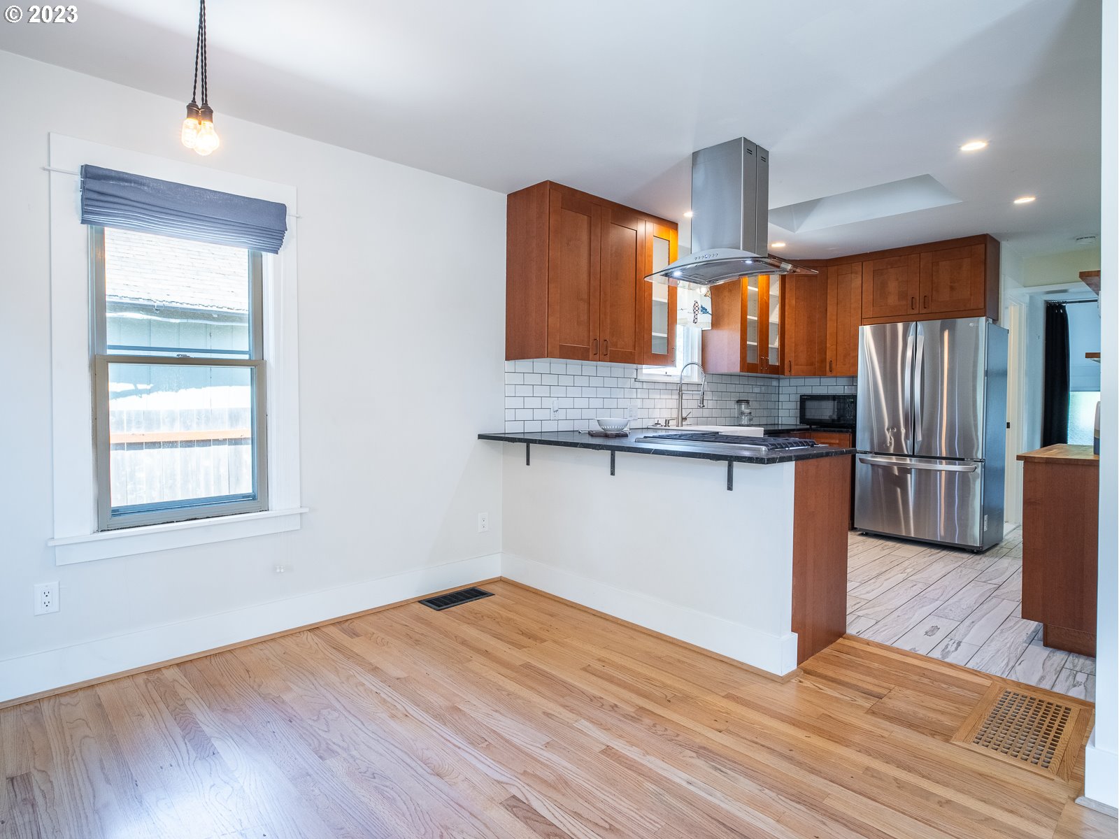 903 North Winchell Street Portland, OR 97217 - Photo 7 of 34 a kitchen with granite countertop wooden floors and stainless steel appliances