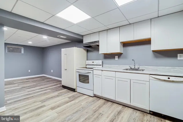 a kitchen with granite countertop white cabinets and white appliances