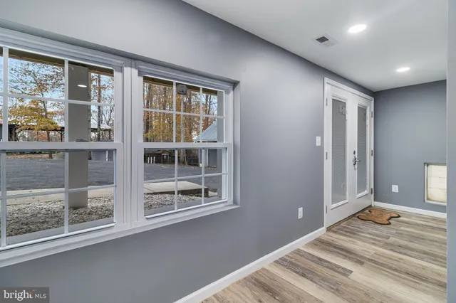 a view of a bedroom with wooden floor and a window