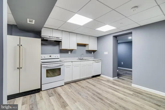 a kitchen with stainless steel appliances a sink cabinets and wooden floor