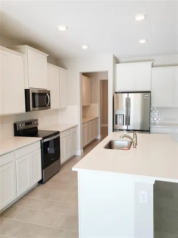 a kitchen with a sink a stove and refrigerator