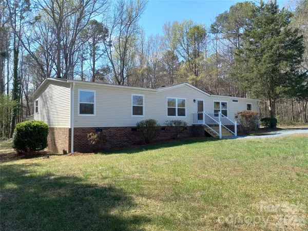 a view of a house with a yard and trees