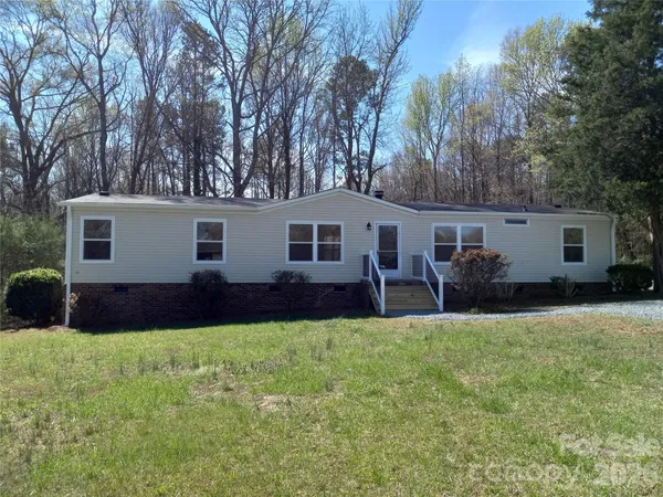 a front view of a house with a yard and trees