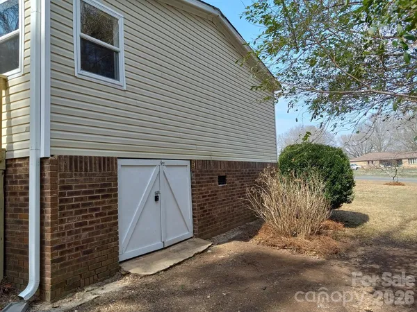 a view of a small house with a yard and garage