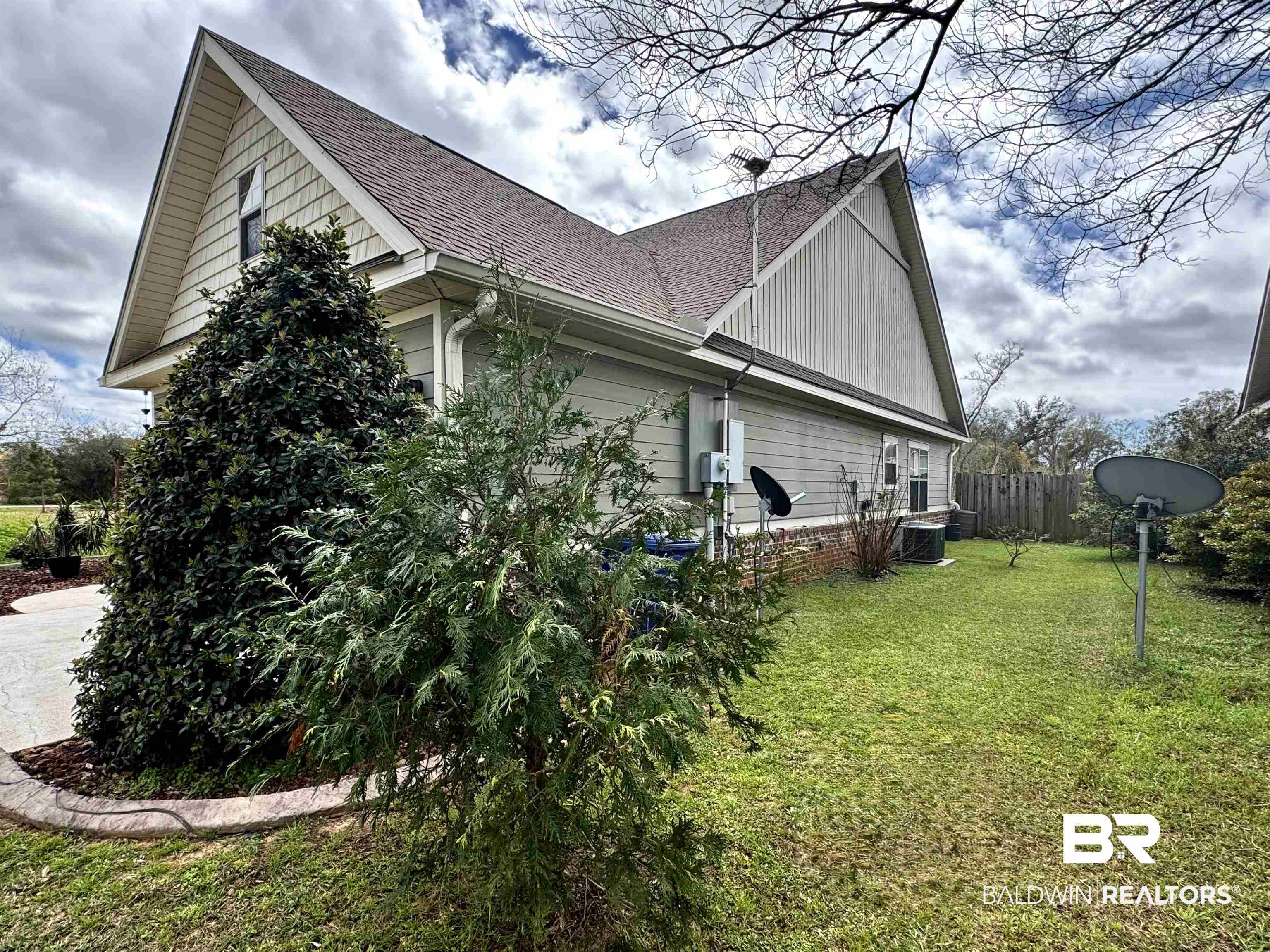 1030 Crown Walk Drive Foley, AL 36535 - Photo 39 of 40 View of home's exterior featuring central air condition unit, a lawn, fence, roof with shingles, and an attached garage