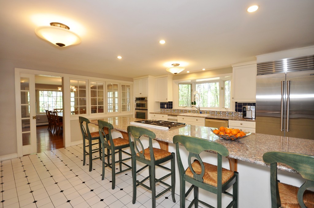 12 Rambling Road Sudbury, MA 01776 - Photo 9 of 26 a kitchen with stainless steel appliances granite countertop a table and chairs