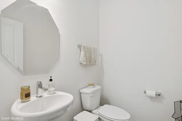 a bathroom with a toilet a sink and mirror