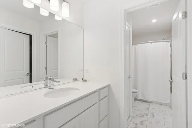 a bathroom with a sink a toilet and a mirror