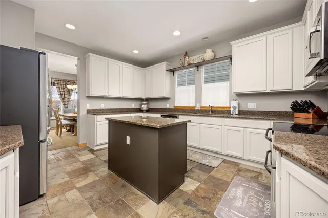 a kitchen with stainless steel appliances granite countertop a stove a sink and a refrigerator