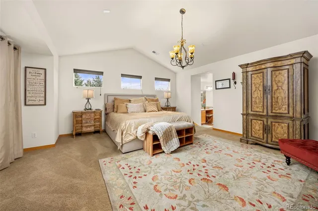 a bedroom with a large bed and a chandelier